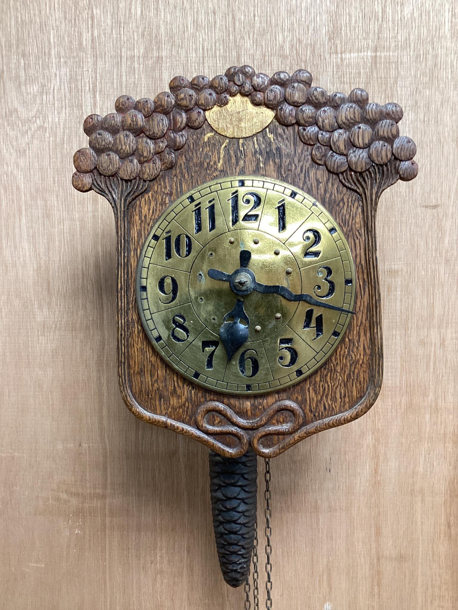 An early 20th century German Jugendstil oak wall timepiece, four miniature Black Forest timepieces and three floral enamelled examples, largest 23cms high